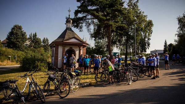 Fahrradwallfahrer versammeln sich vor der Friedenskapelle in Walldürn zum Beginn der Rundfahrt für den Frieden